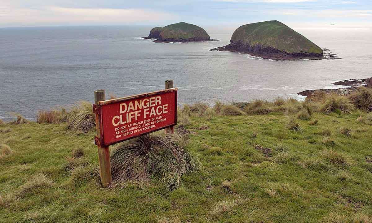 Cliff warning sign at Cape Grim, Tasmania, Gary Houston, 2016, via Wikimedia Commons