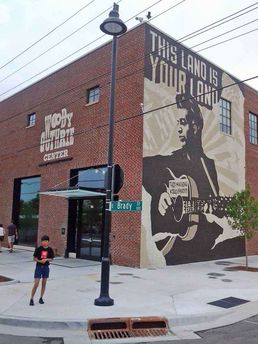 This Land is Your Land, mural on the side of the Woody Guthrie Centre, Tulsa, Oklahoma, Source: Wikimedia Commons